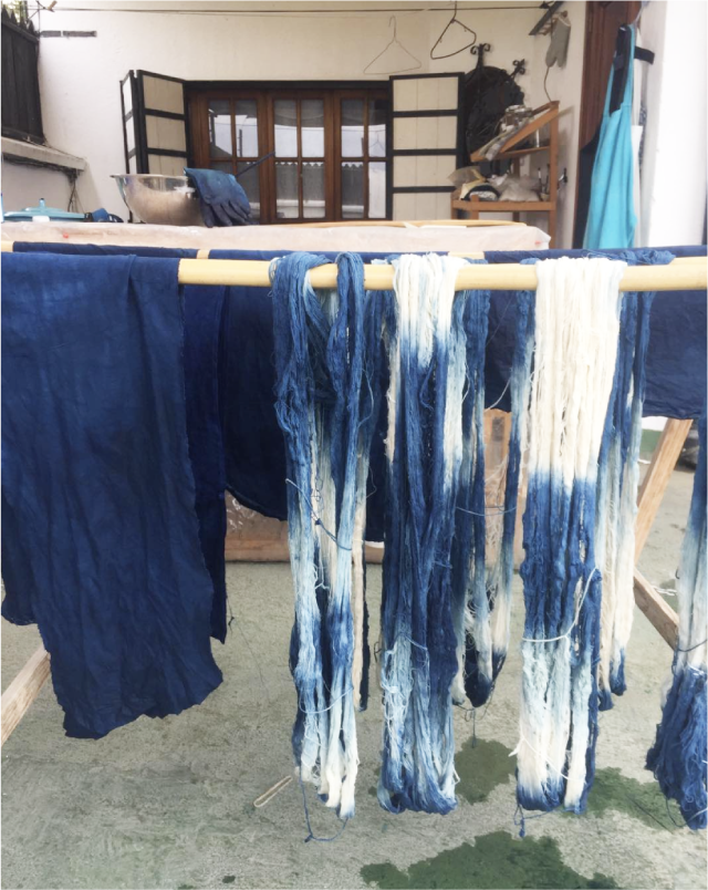 Hanging indigo-dyed textile strips, no pillow visible