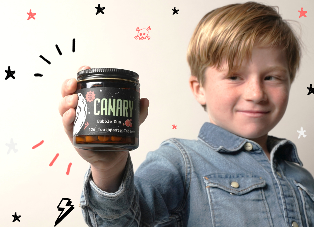 Child holding a CANARY bubble gum toothpaste tablet jar