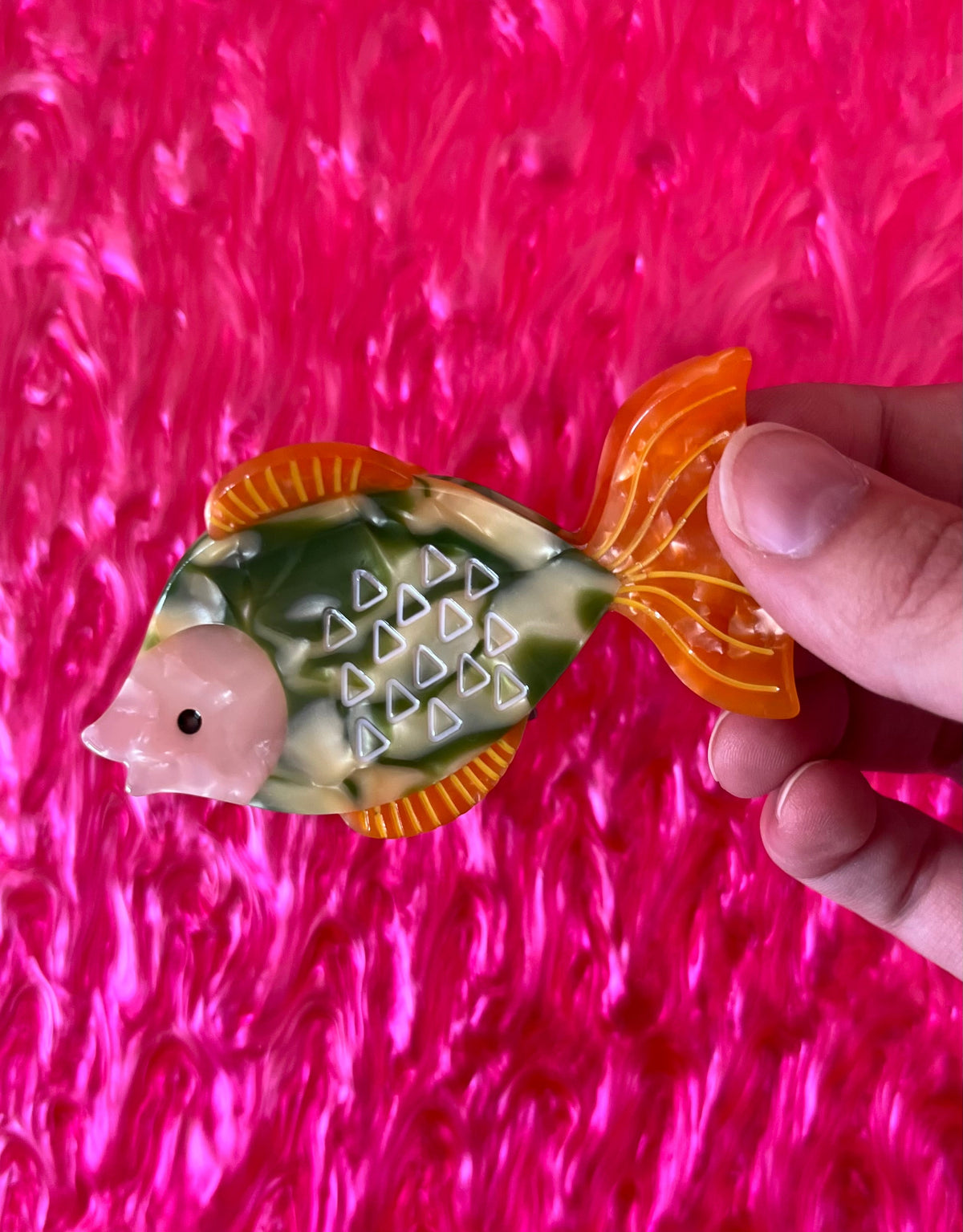 Ocean-themed hair claw shaped like an orange and green fish