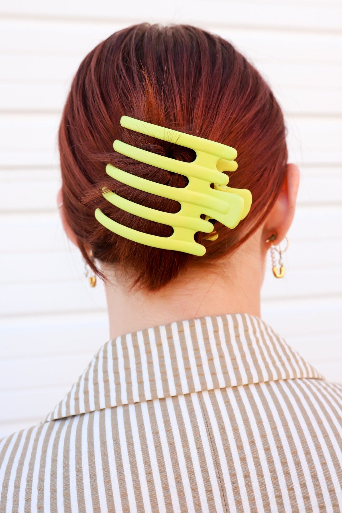 Wide hair claw clip in lime yellow on dark red hair