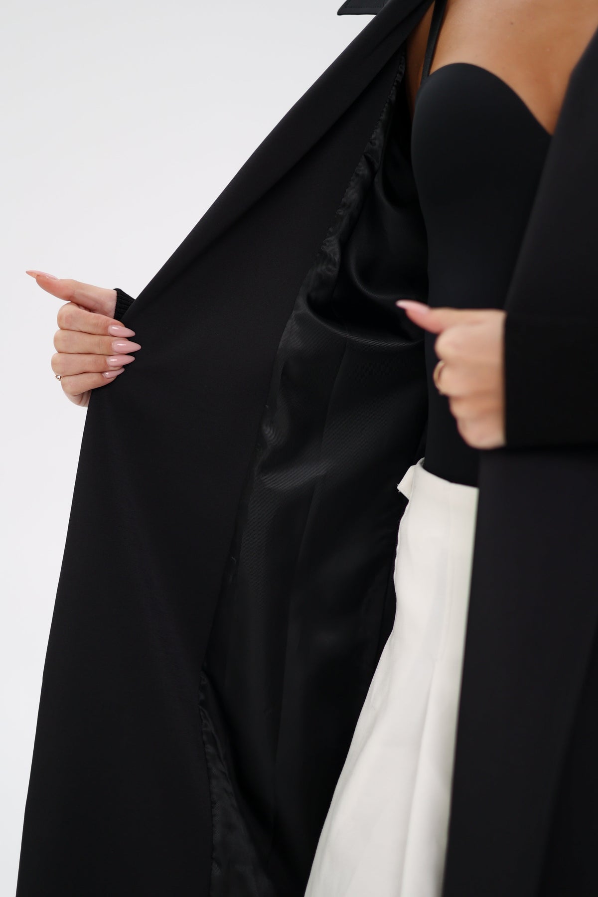 Black trench coat opened to show its smooth dark lining
