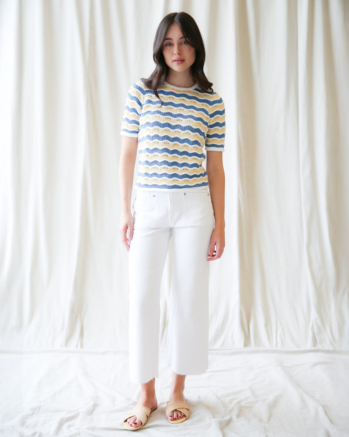 Striped knit sweater with blue and yellow wavy bands, crew neck, short sleeves