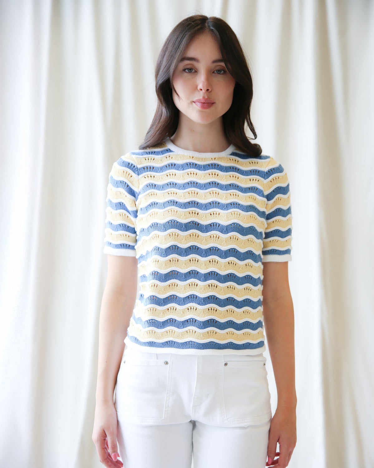 Striped knit sweater with blue and yellow wavy bands, crew neck, short sleeves