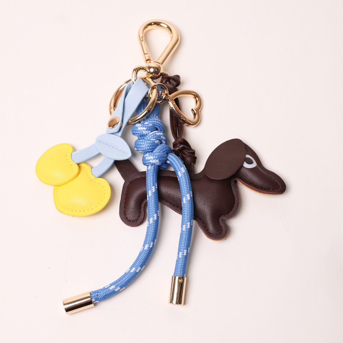 Blue braided keychain with brown dog charms and yellow heart-style charms