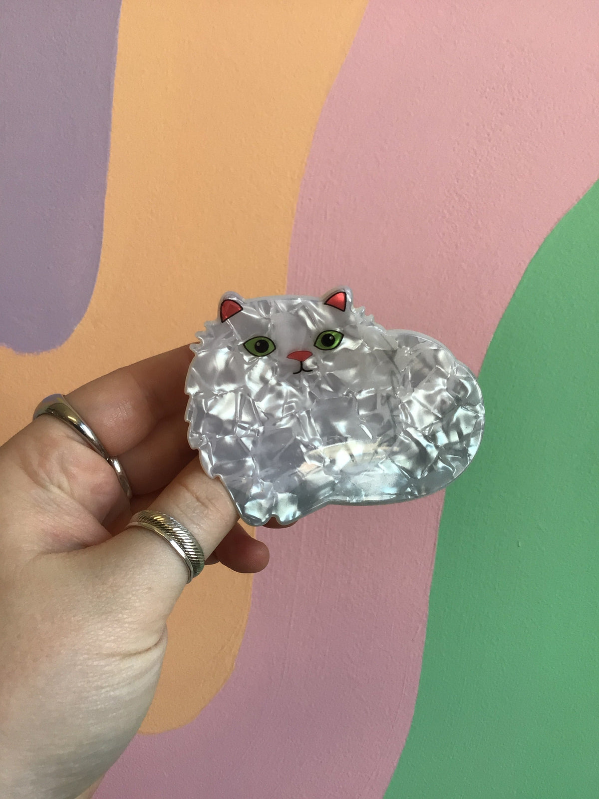Clear white cat hair claw with green eyes, red nose, and red ear accents