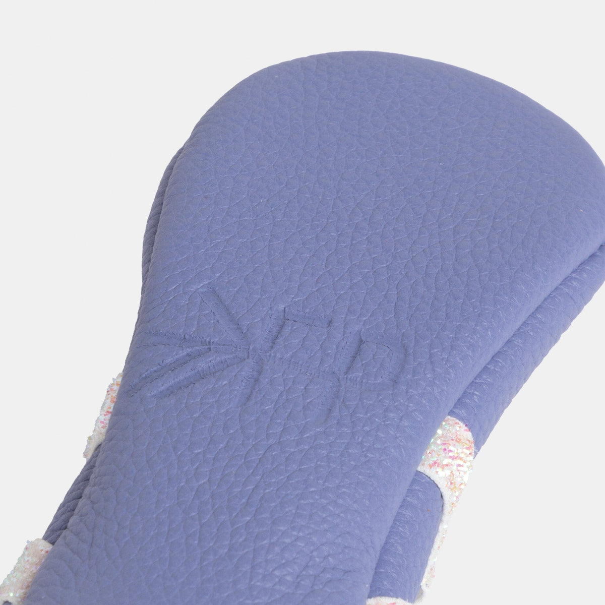 Close-up of lilac baby slipper upper with textured leather-look finish and bow strap