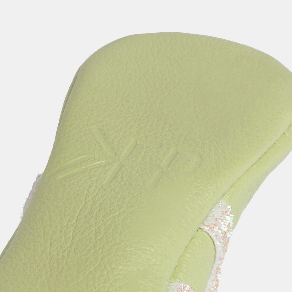 Mint baby slipper upper close-up with pebble texture and glitter-trim edge