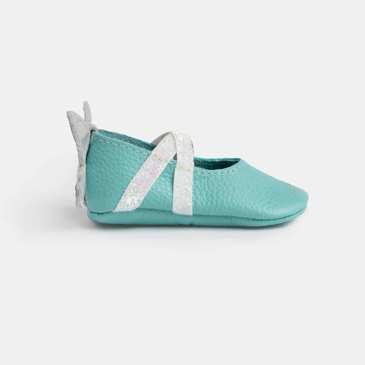 Turquoise baby ballet slipper shoe, side view with white glitter ribbon