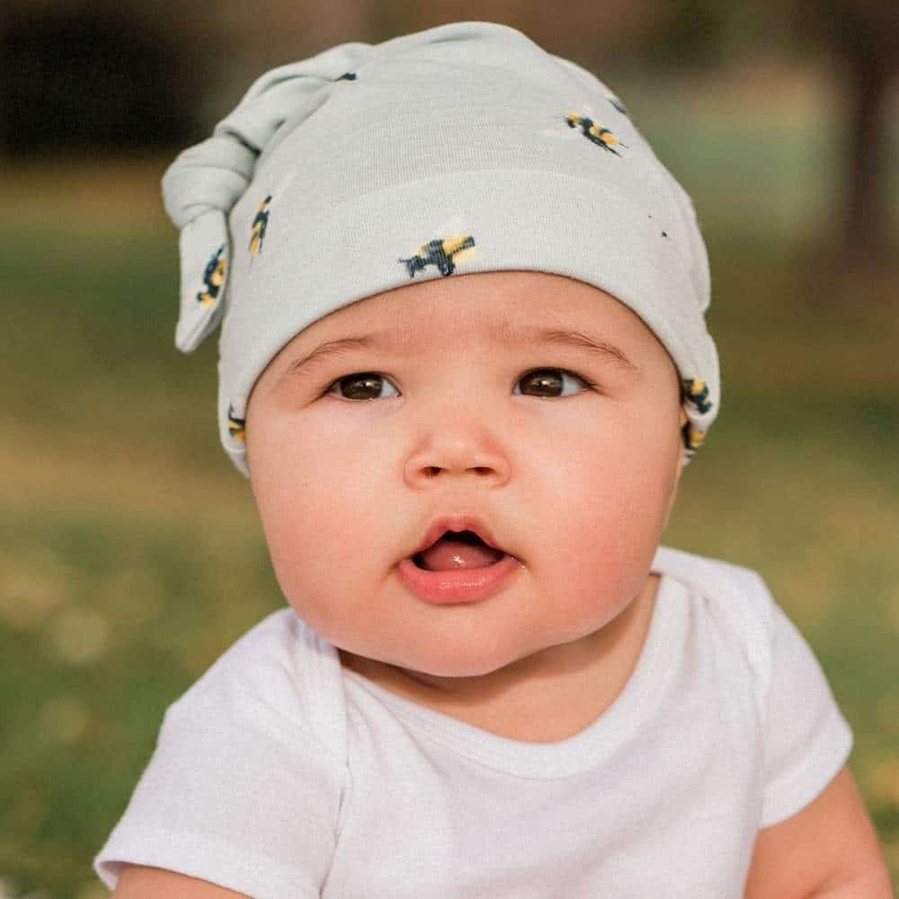 Light gray knotted beanie with small sheep print and ribbed brim