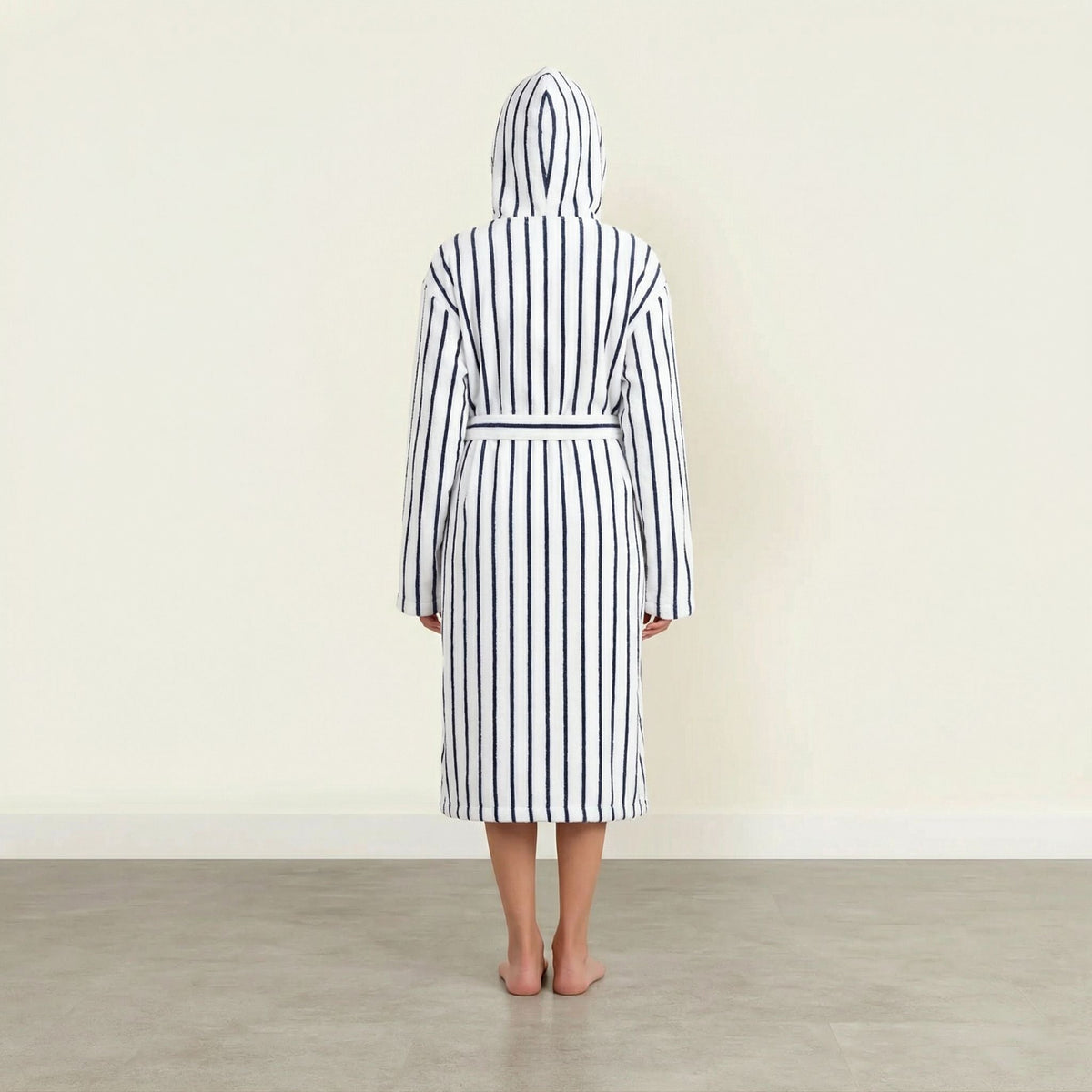 Back view of striped cotton bathrobe with hood and belt tie, white with navy vertical stripes