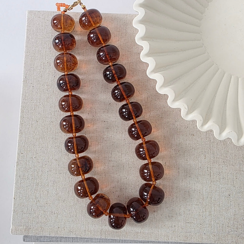 Amber beaded necklace with round brown beads and clasp