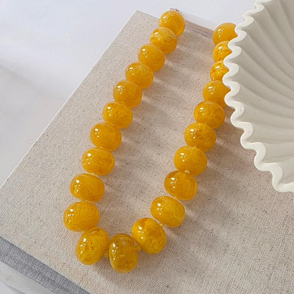 Yellow beaded necklace with round amber beads and clasp