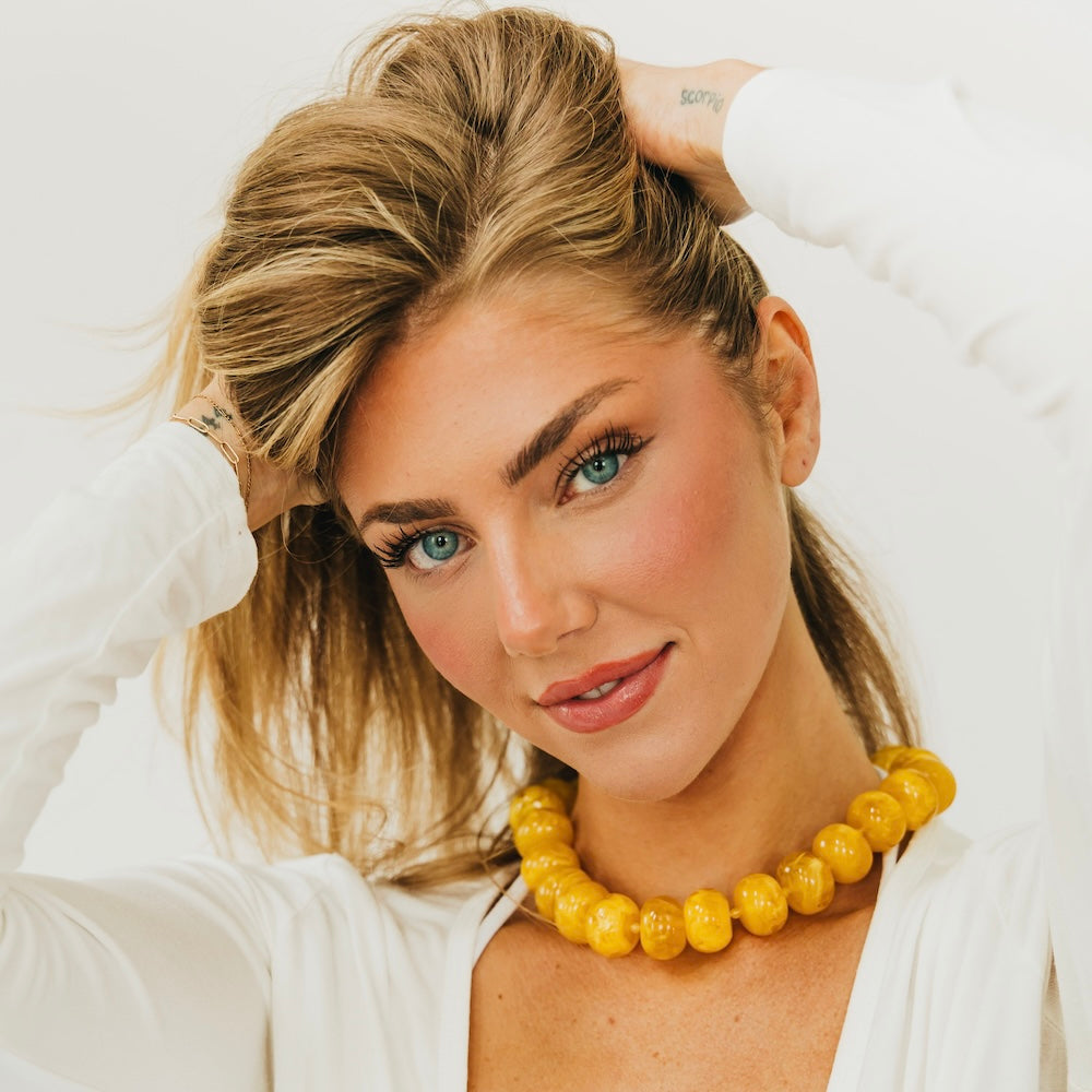 Amber yellow beaded necklace with chunky round beads and white top