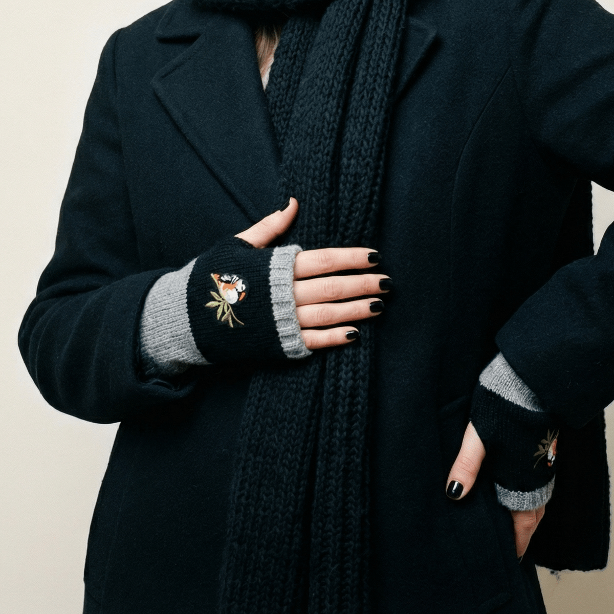 Black knitted fingerless arm warmer with gray cuff and bird applique