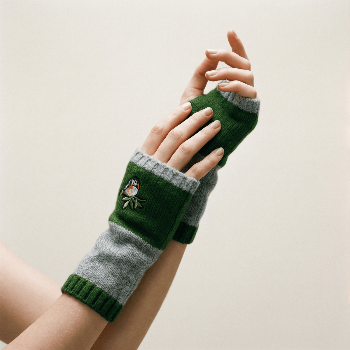 Green and gray knitted bird-applique fingerless arm warmers with striped cuffs