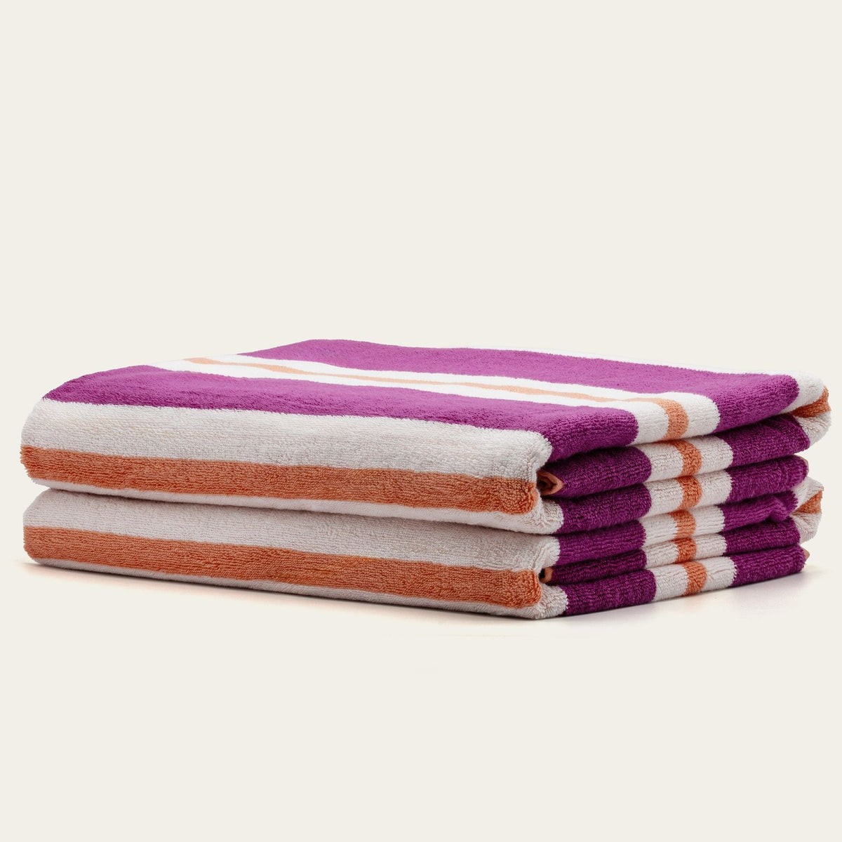 Stack of cotton beach towels with purple, white, and orange horizontal stripes