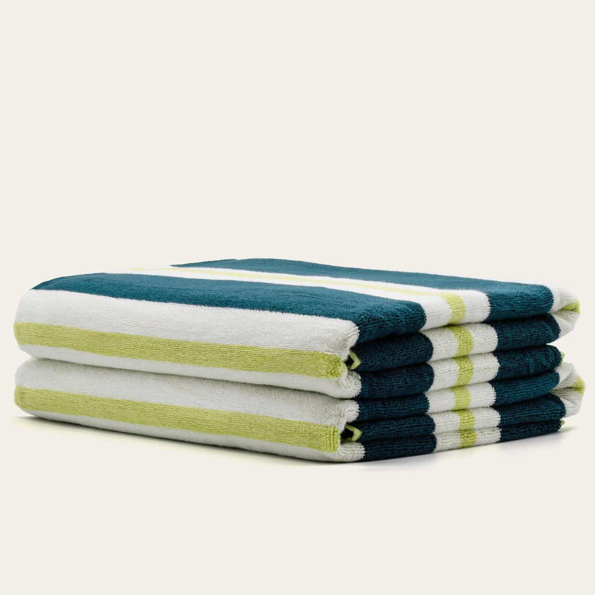 Stacked cotton beach towels with teal, white, and lime striped design
