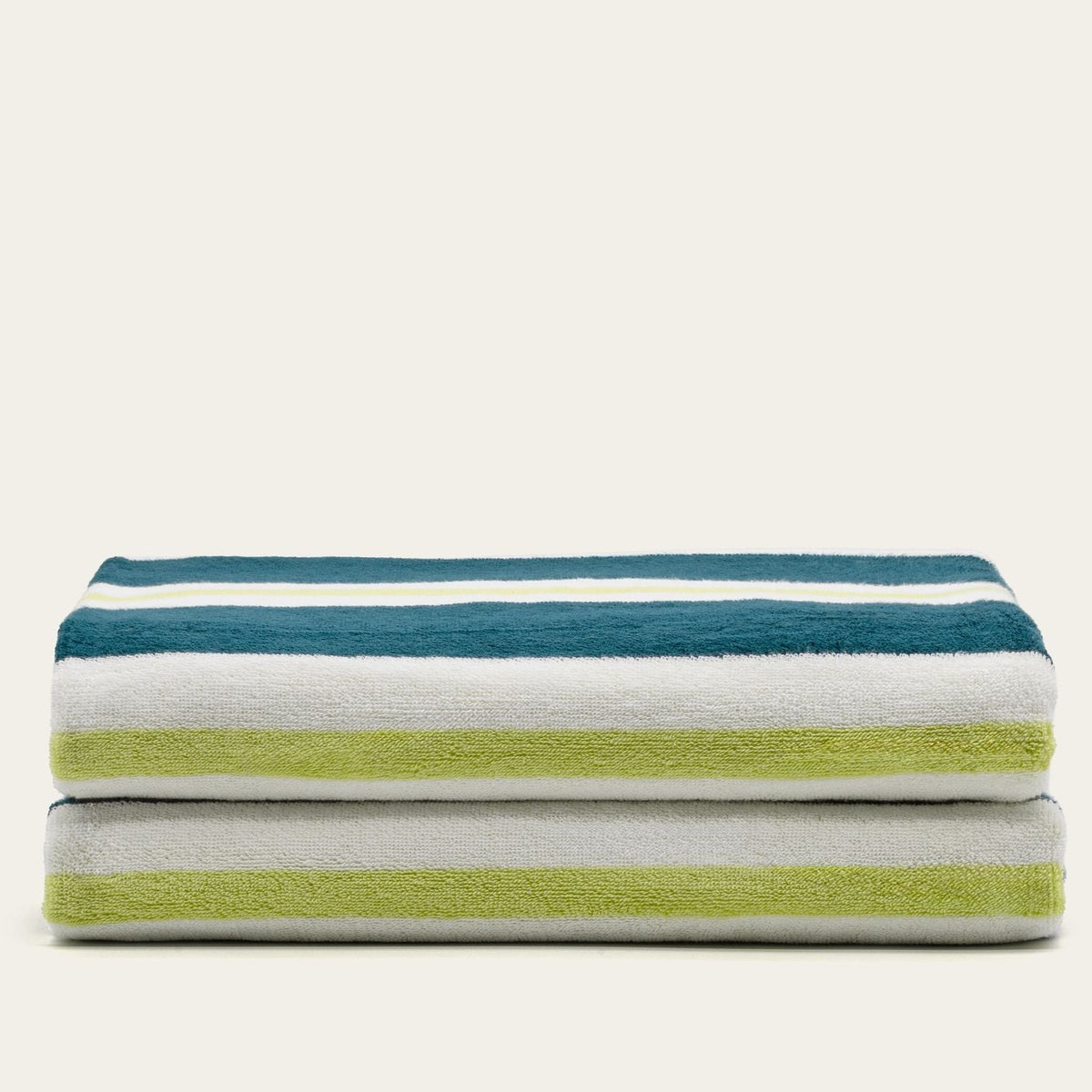 Folded cotton beach towels with teal, white, and lime horizontal stripes