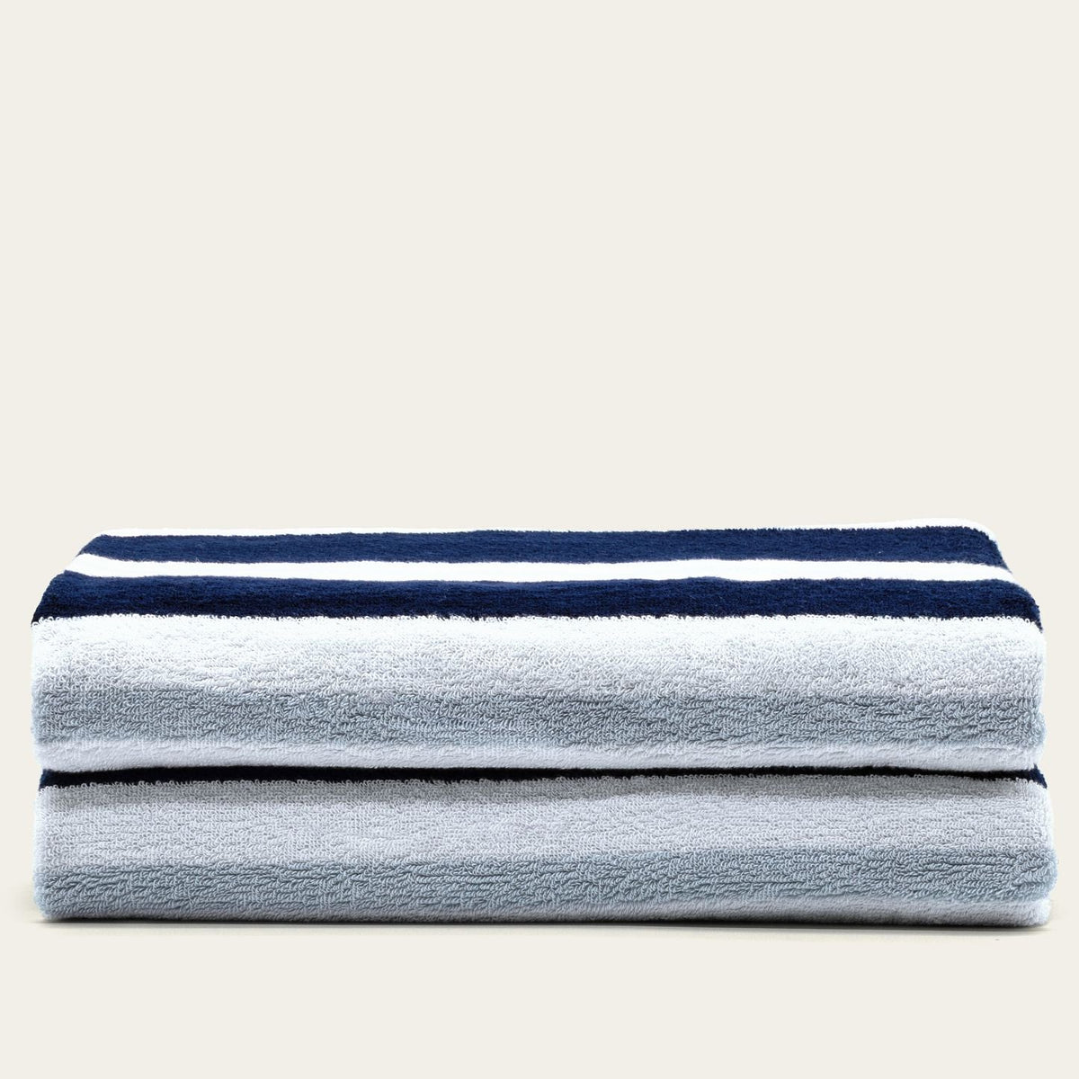 Cotton beach towel stack with navy-and-white horizontal stripes, soft gray body