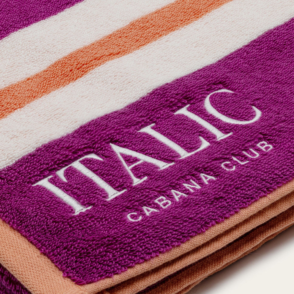 Purple and white striped cotton beach towel with ITALIC logo and label