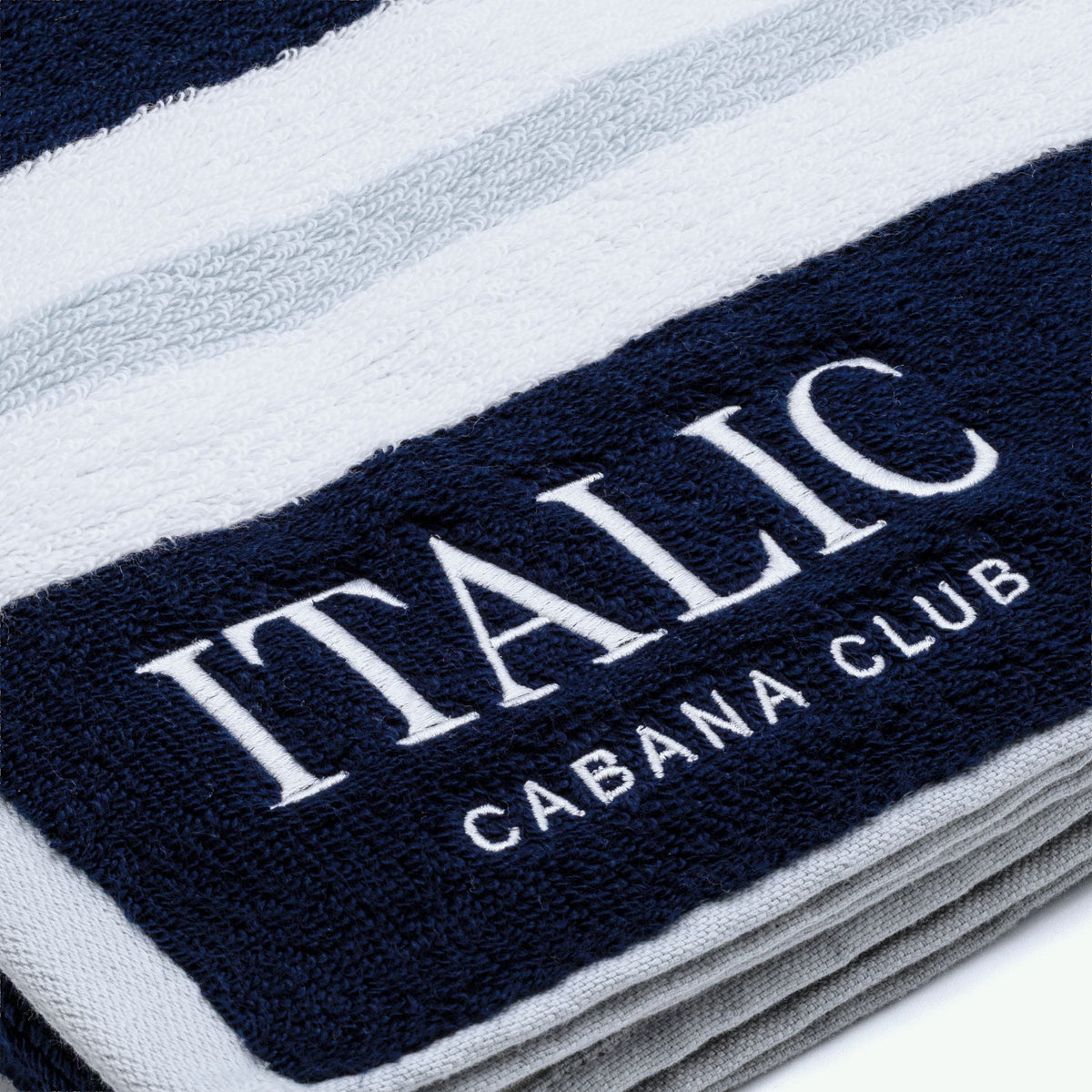 Navy logo stripe with 'ITALIC' text on white cotton beach towel