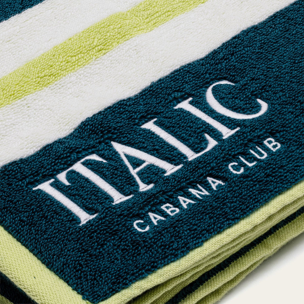 Navy logo stripe with 'ITALIC' text on white cotton beach towel, lime accent