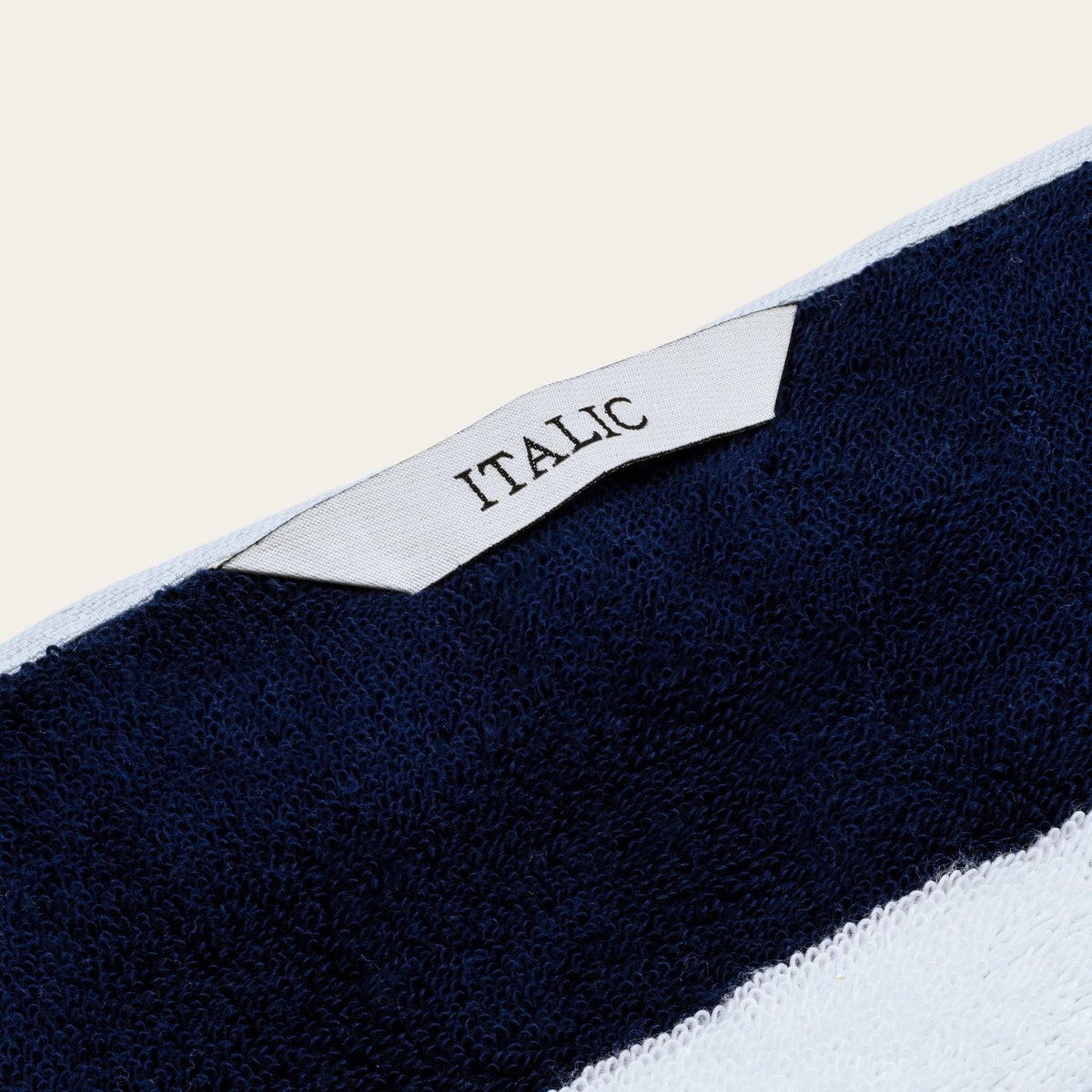 Corner label reading 'ITALIC' on navy and white striped cotton towel