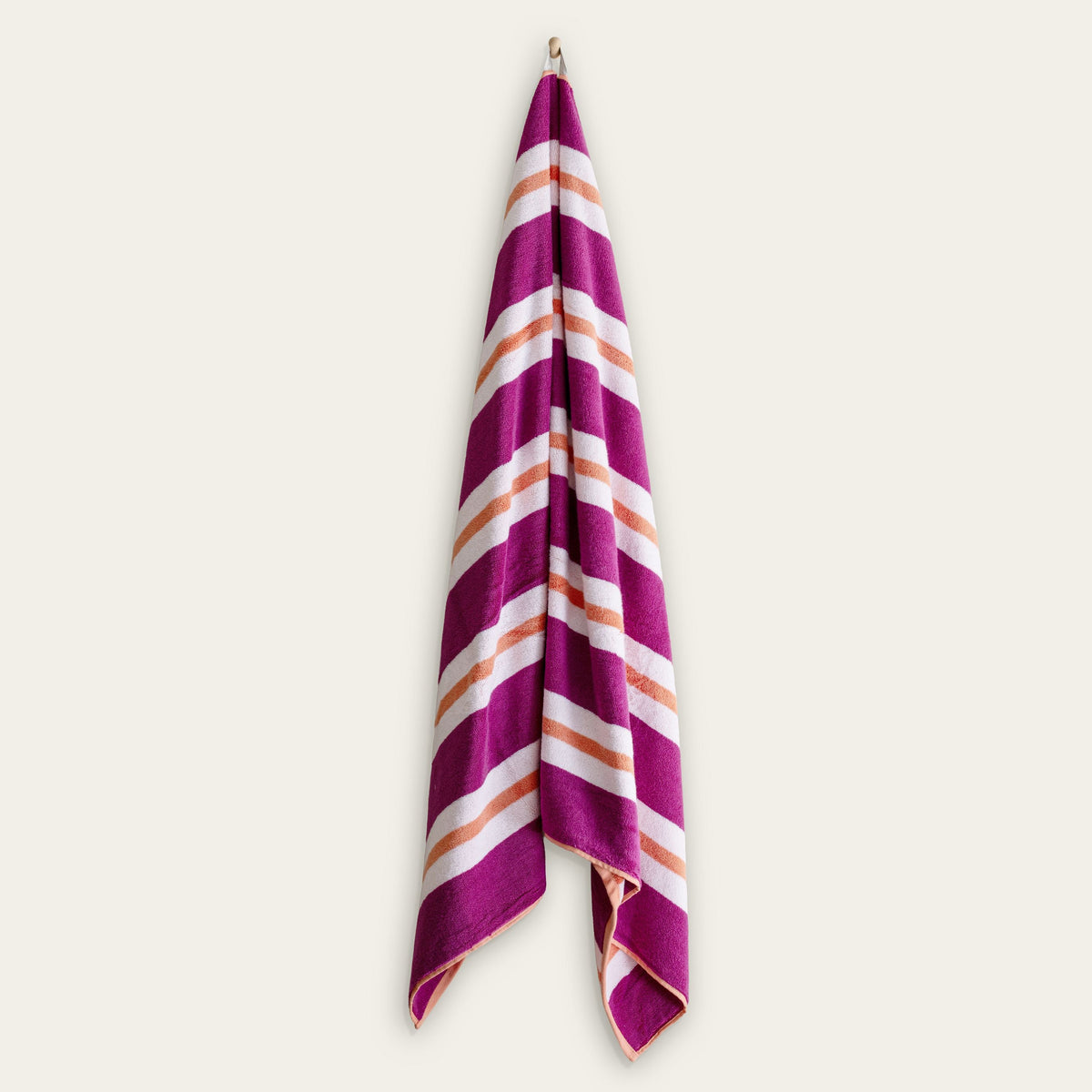 Purple, white, and orange striped cotton beach towel folded vertically