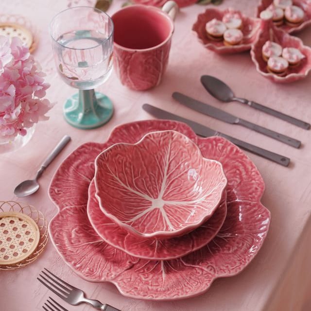 Stacked pink ceramic cabbage-leaf salad bowls with embossed leaf-vein design