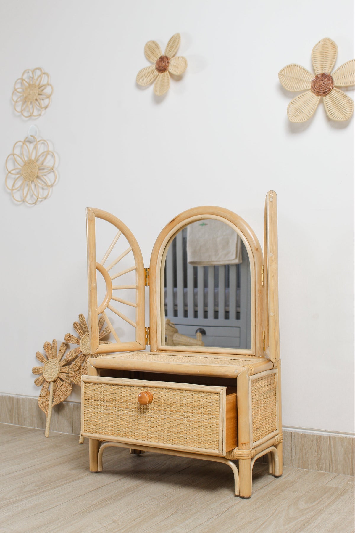 Natural rattan flower wall decorations displayed above a woven dresser