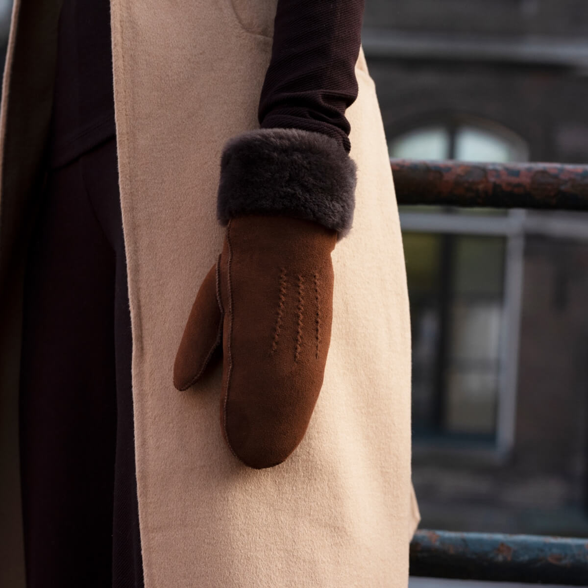 Brown suede mitten with dark fur cuff and stitched detail, side view