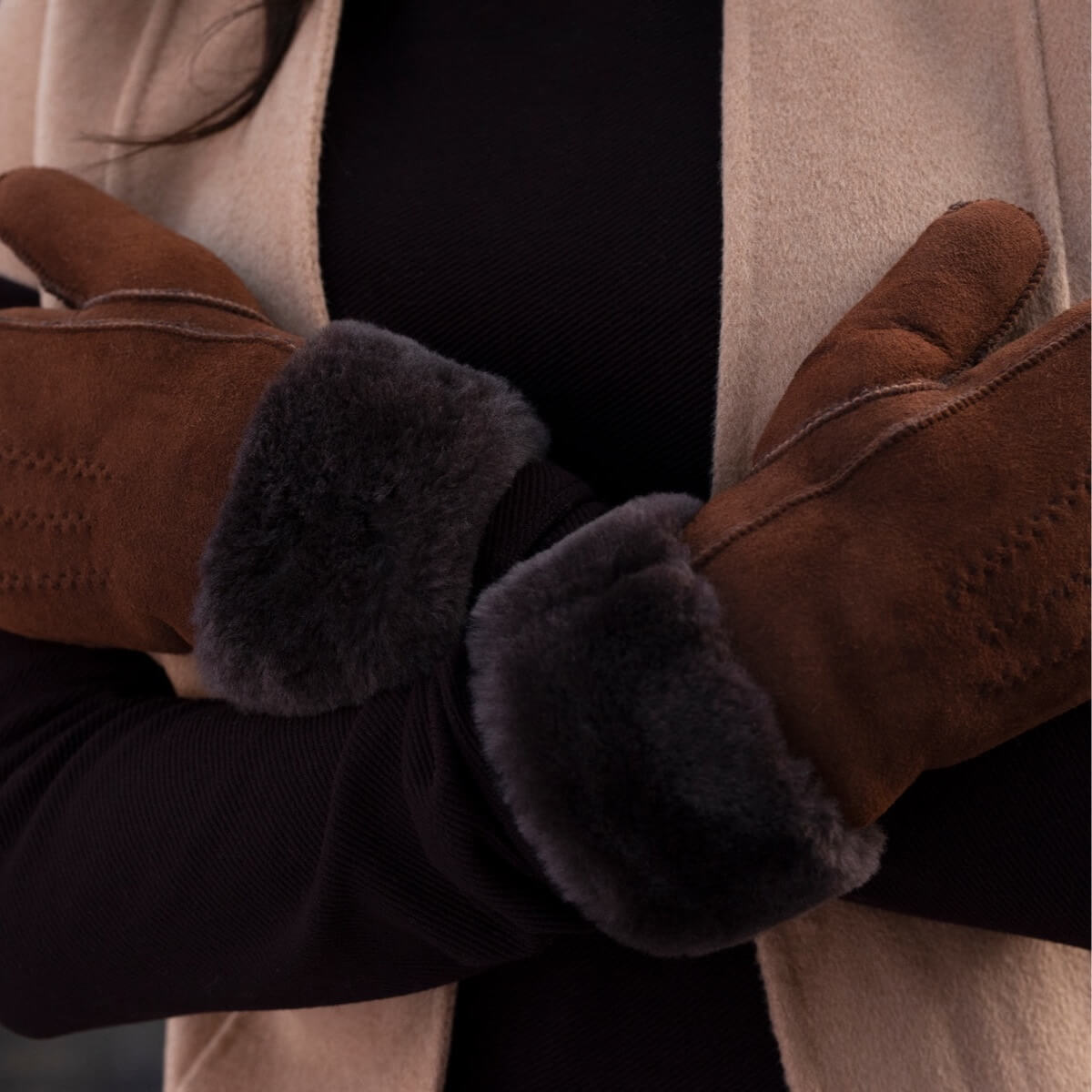 Brown suede mitten with dark fur cuff and stitched seams, close-up