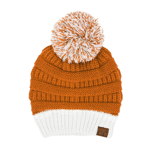 Burnt orange knit beanie with white pom-pom and C.C logo patch at cuff