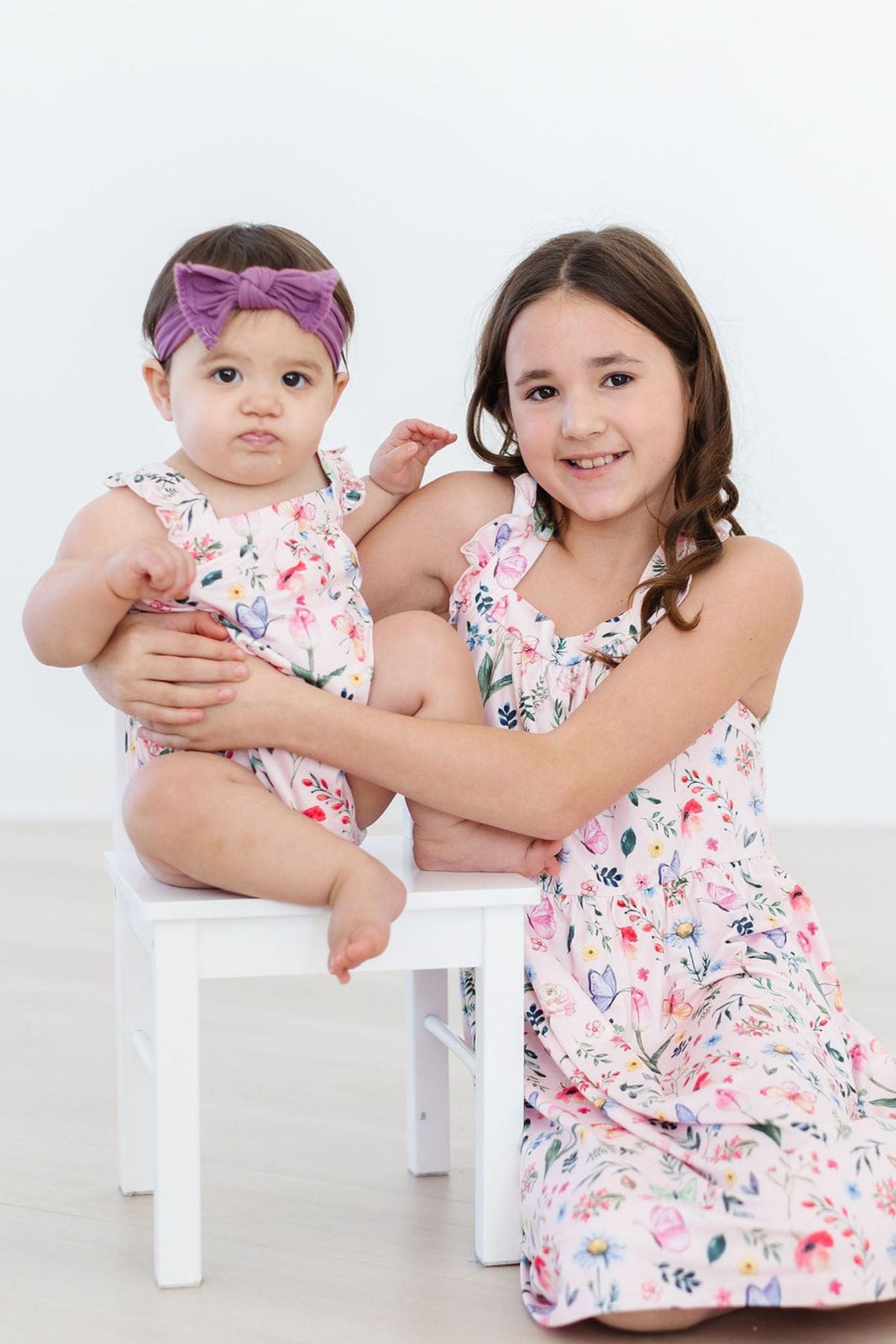 Floral sleeveless romper with ruffled cross-back and matching diaper cover