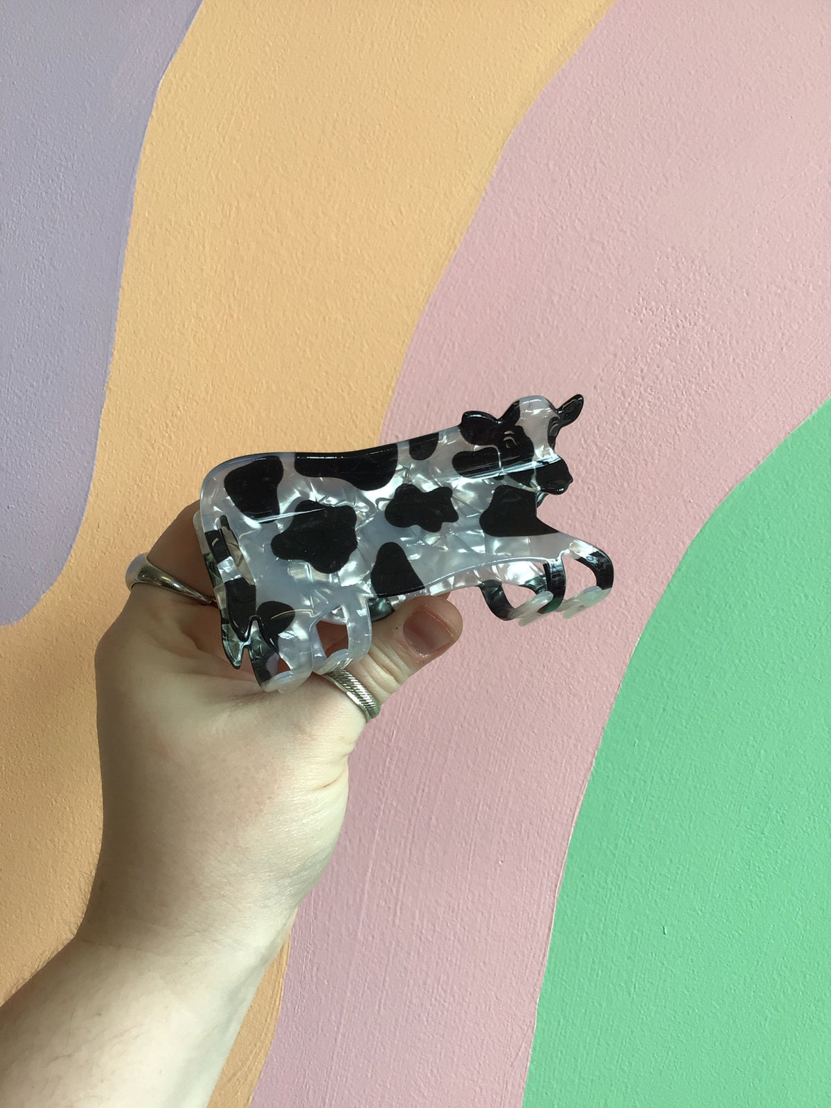 Black-and-white cow hair claw with speckled spots, glossy cartoon design