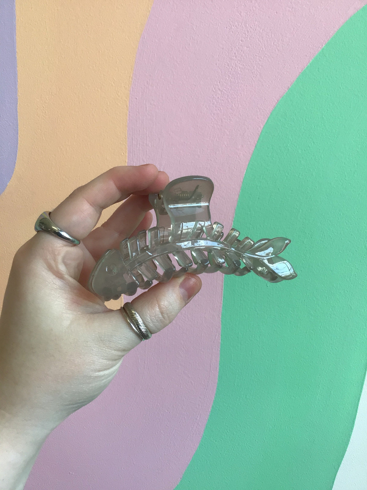 Clear/gray fish-shaped hair claw with translucent look and ribbed center detail