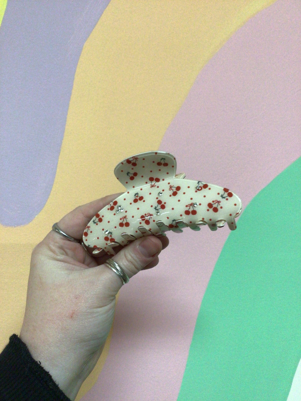 Cream toile hair claw clip with red cherry pattern and curved metal teeth