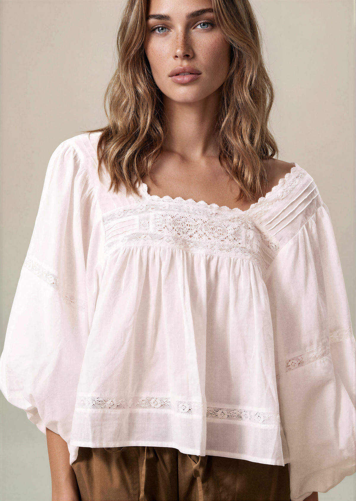 White puff sleeve blouse with lace-trim square neckline and gathered peplum hem