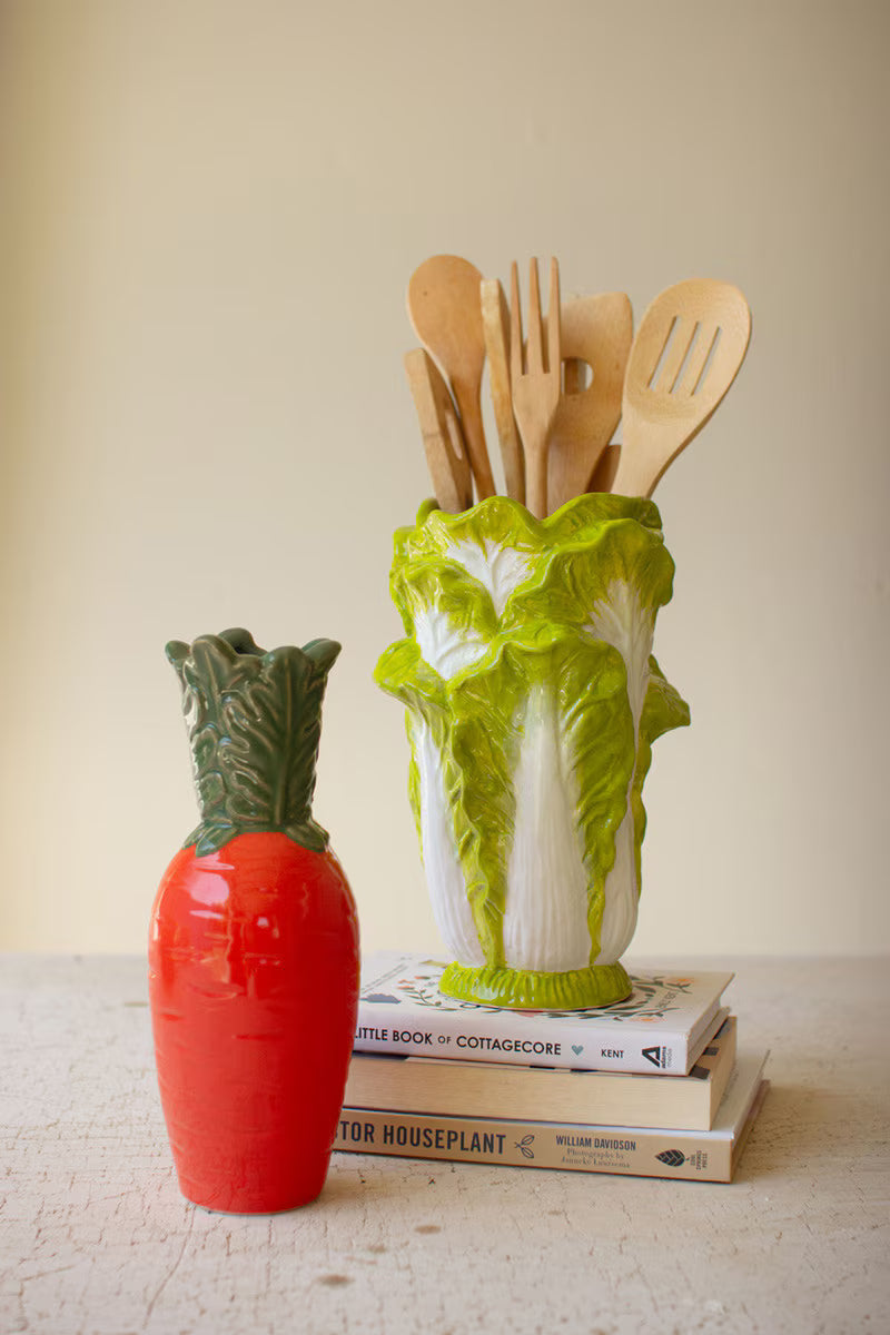 Orange ceramic carrot vase with glossy orange body and ruffled green leaves
