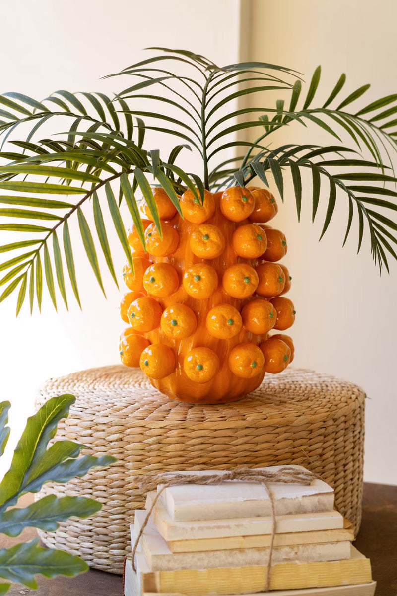 Orange ceramic cluster vase with hollow top and glossy spheres holding palm fronds