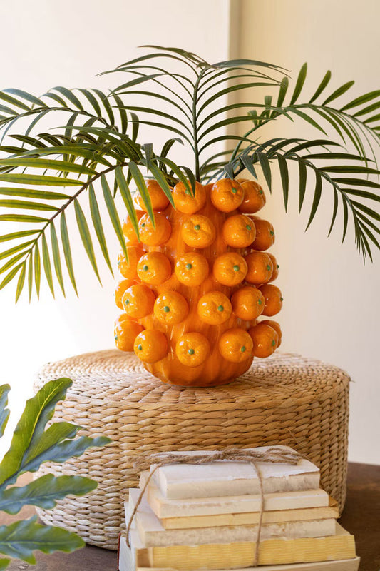 Orange ceramic cluster vase with hollow top and glossy spheres holding palm fronds