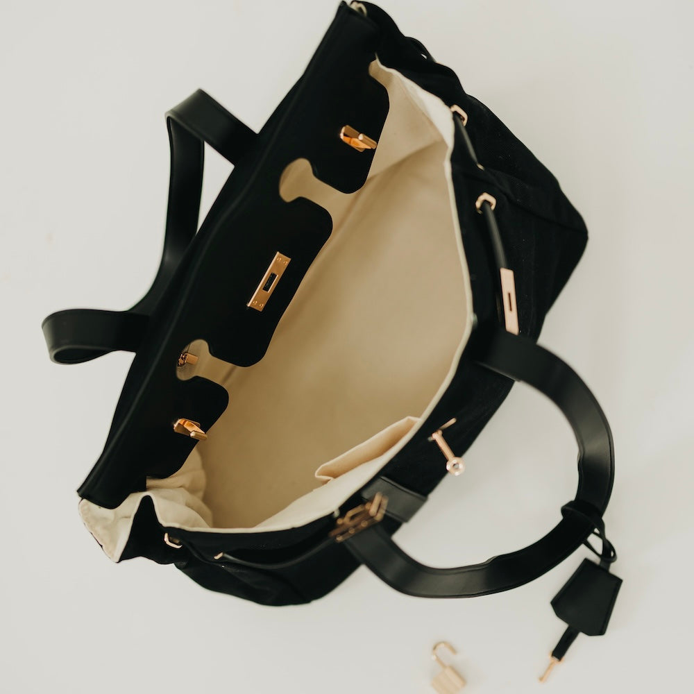 Black canvas and vegan leather tote with beige interior and open top