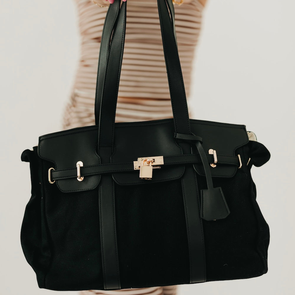 Black canvas and vegan leather tote with gold-tone hardware and front straps
