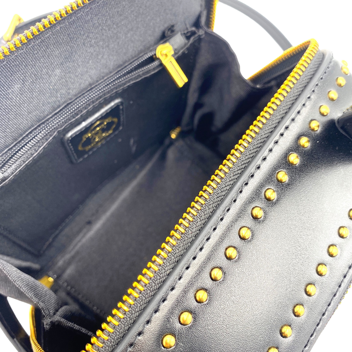 Black leather handbag interior with fabric lining and gold zipper