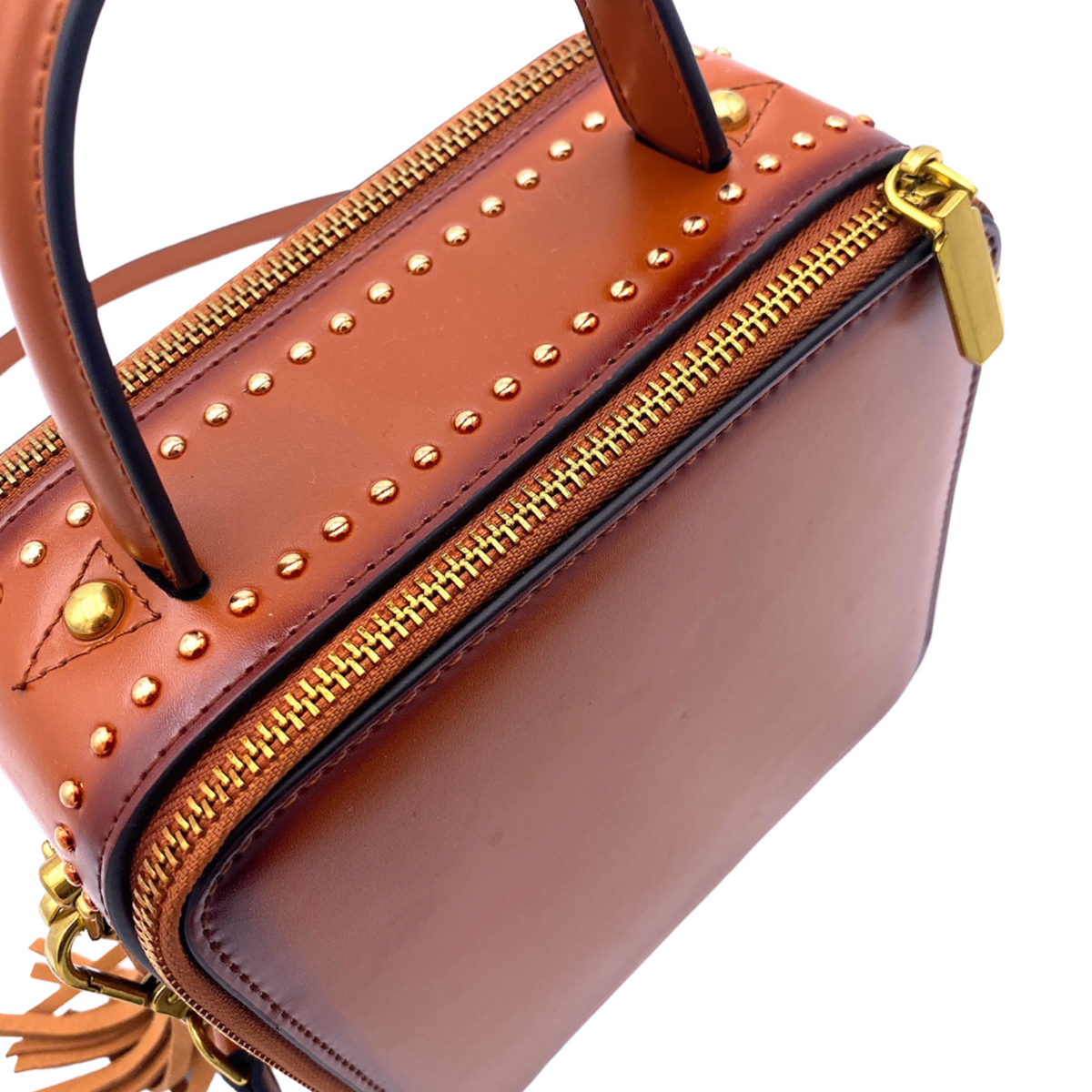Saddle mini handbag front with gold studs, zip closure, and leather trim