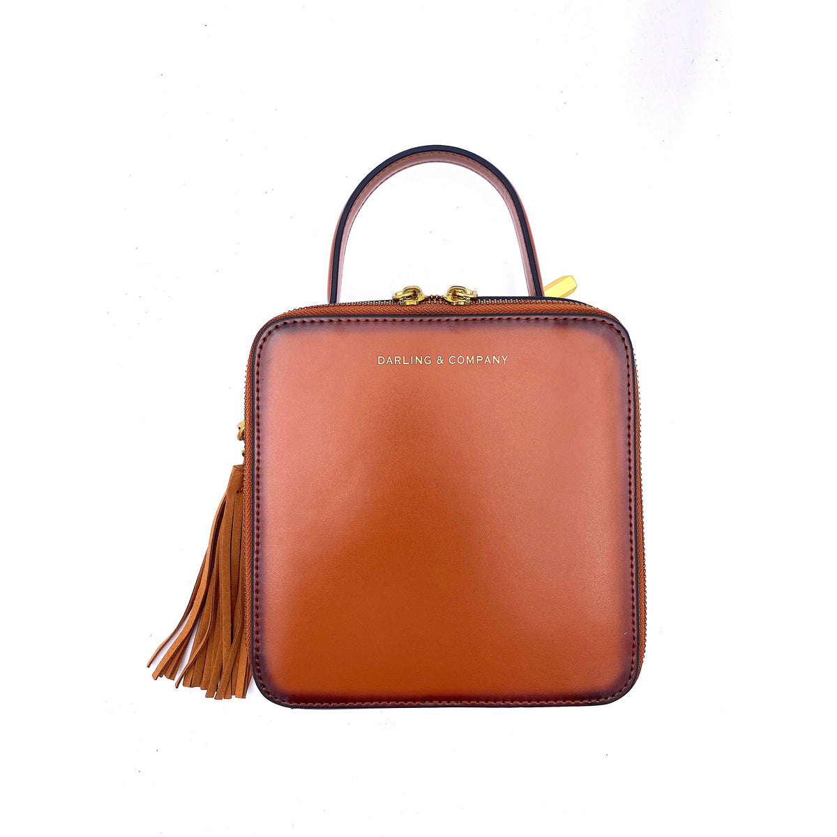 Saddle-colored mini leather handbag with top handle and gold tassel