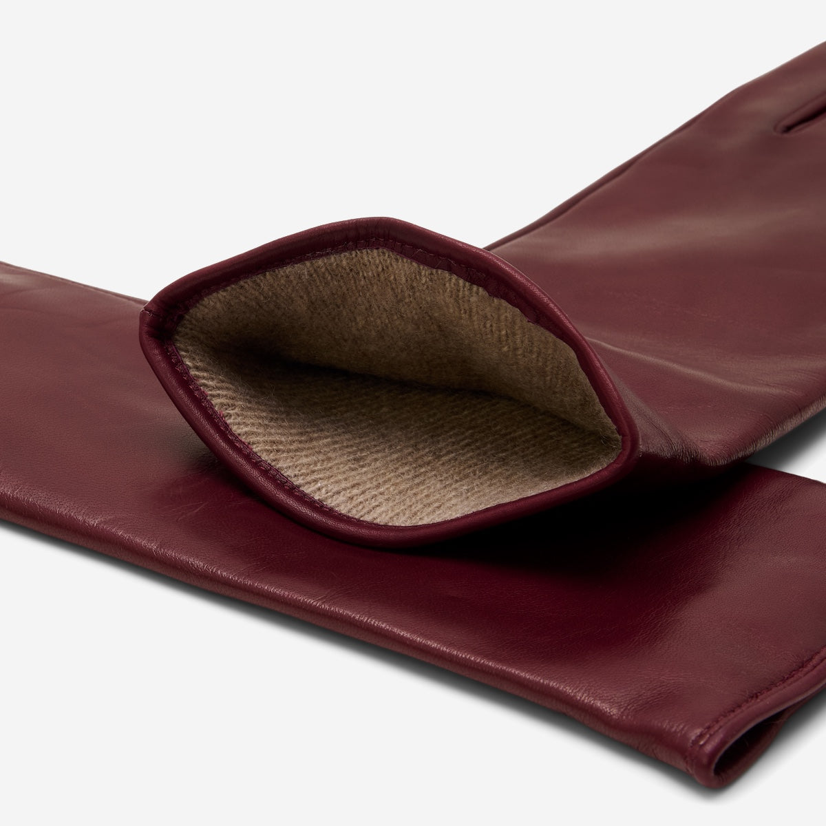 Burgundy leather glove cuff open, showing taupe cashmere lining inside.