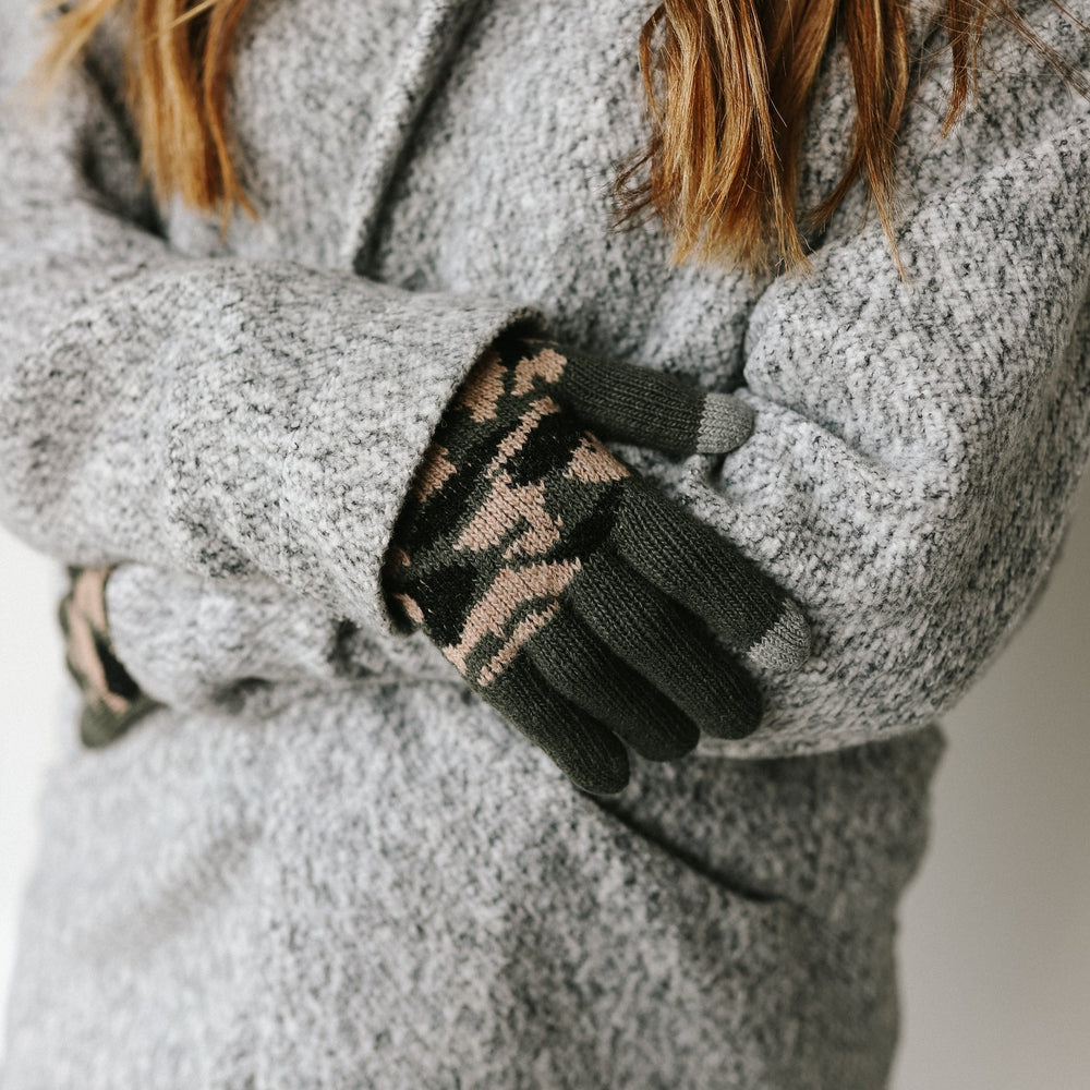 Dark green camo knit smart-touch gloves shown while wearing a gray coat
