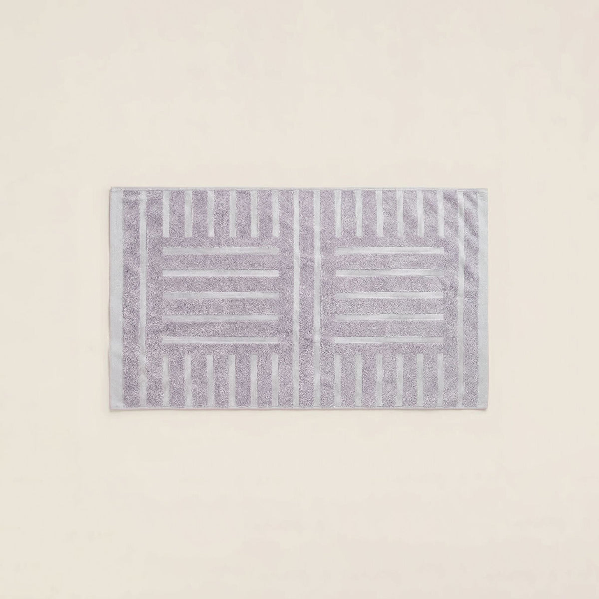 Lavender cotton towel with patterned border, folded and laid flat