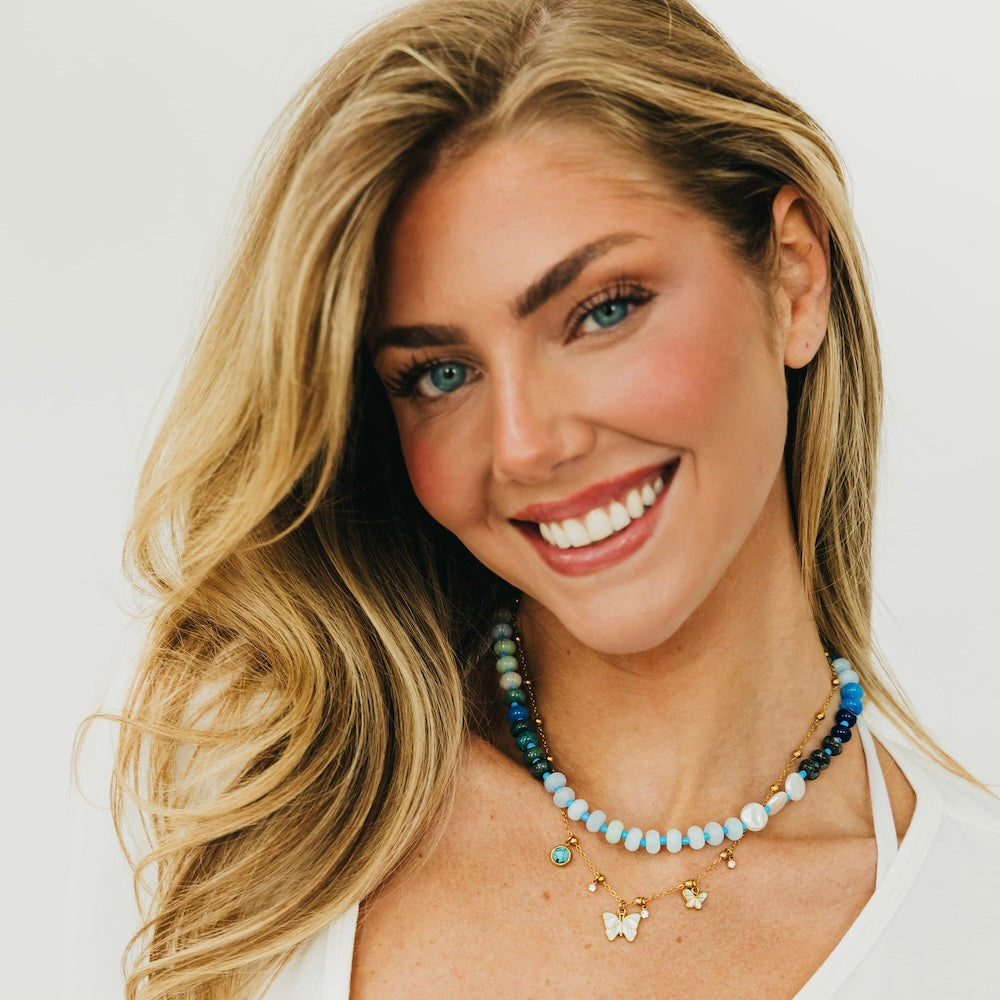 Layered gold necklace set with butterfly charms and blue turquoise beaded collar